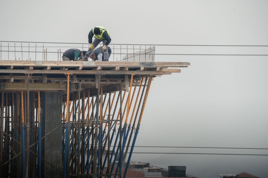 Workers on a high-rise building construction site showcasing teamwork and safety.