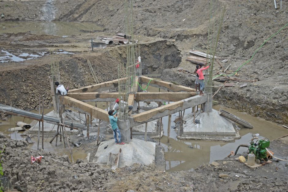 Workers constructing a building foundation with rebar and wooden supports