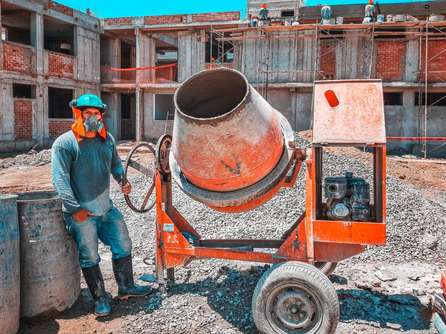 A construction worker operating a concrete mixer at an active building site
