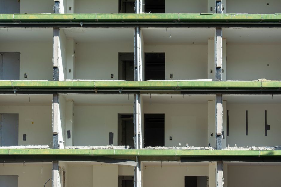 Close-up view of a partially demolished urban building showing exposed concrete and empty rooms.